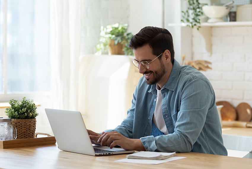Man using a laptop in a bright, modern workspace, illustrating the importance of reliable Wi-Fi connectivity for smart homes and offices.