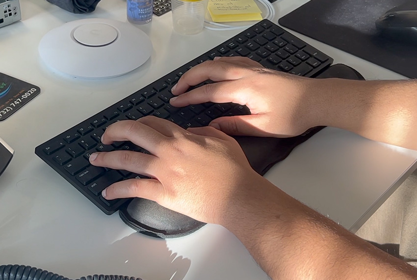 Hands typing on a keyboard, emphasizing computer security and protection against unauthorized access, with a focus on data safety and user engagement.